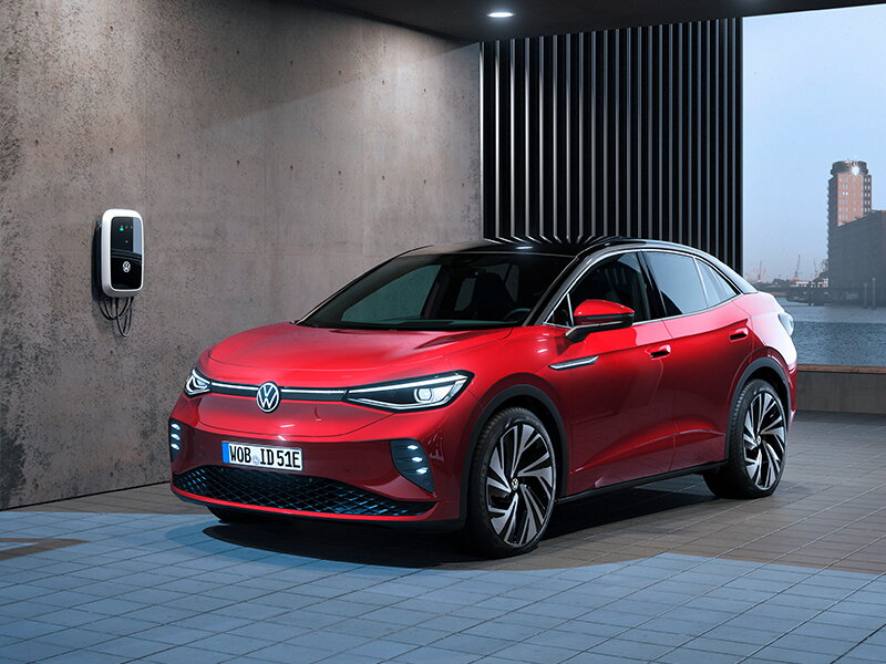 Rode elektrische Volkswagen ID.4 aan het opladen op de oprit via een wallbox
