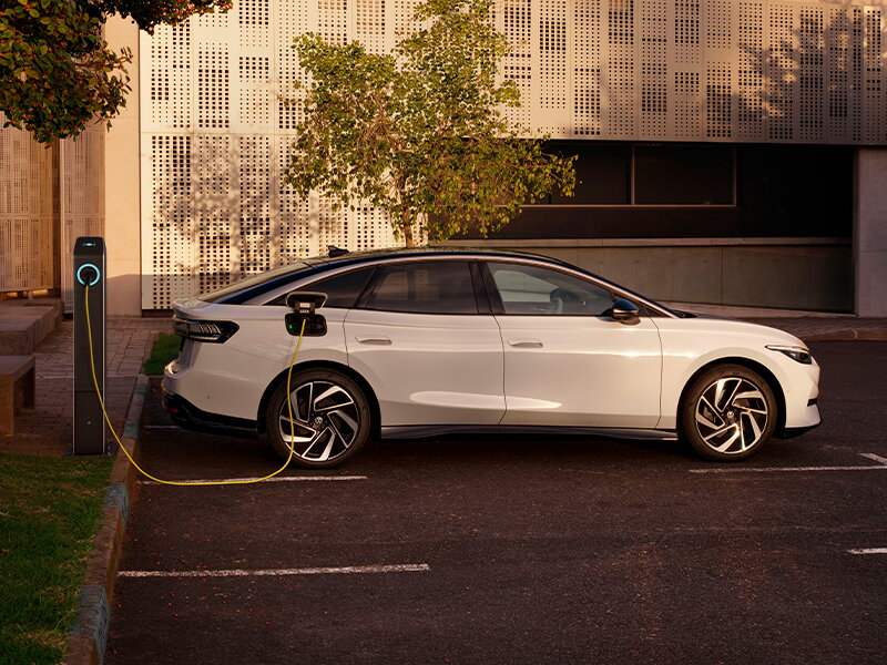 Witte volkswagen ID.7 op parkeerterrein aan het opladen via laadpaal
