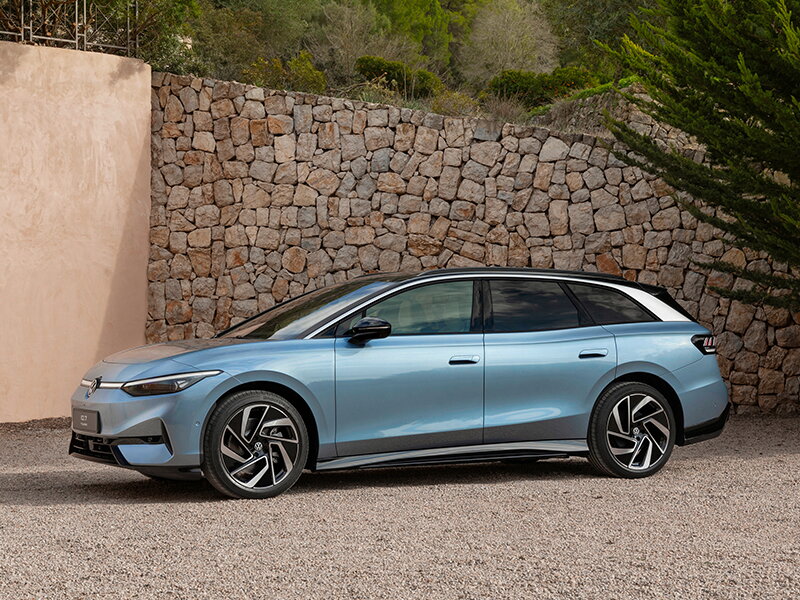 Blauwe Volkswagen ID.7 voor een stenen muur geparkeerd