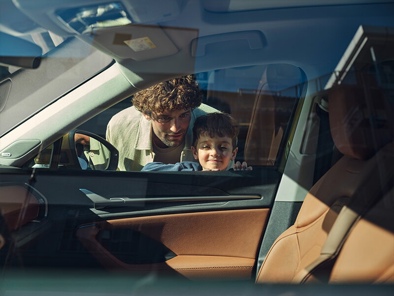Vader en zoon kijken door het raam naar het interieur van de nieuwe Skoda Kodiaq