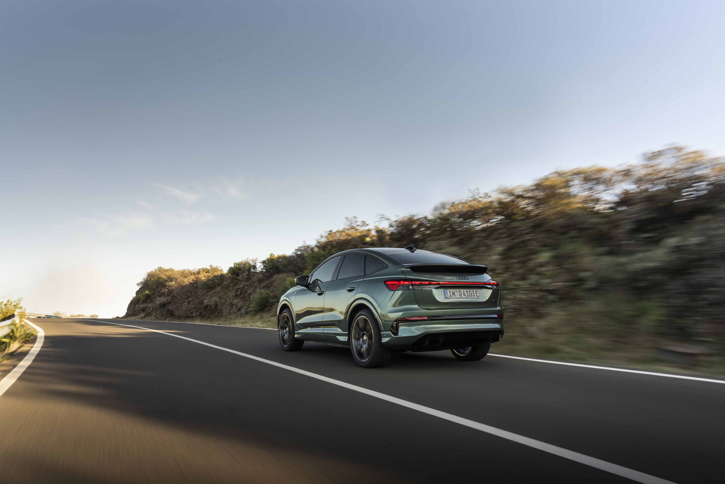 Audi Q4 e-tron rijdend op een bochtige weg in zijaanzicht