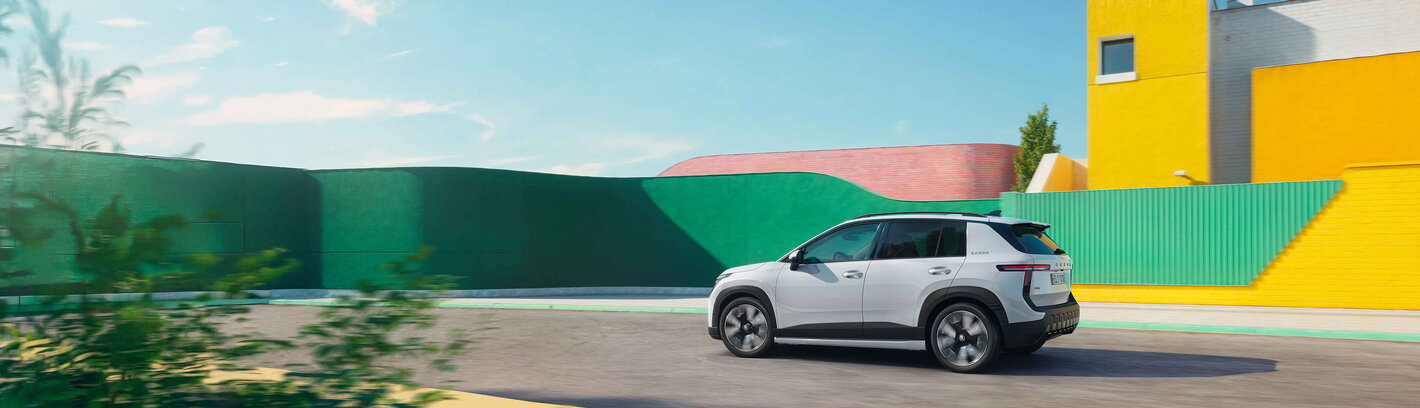 skoda epic witte elektrische suv rijdt de stad binnen
