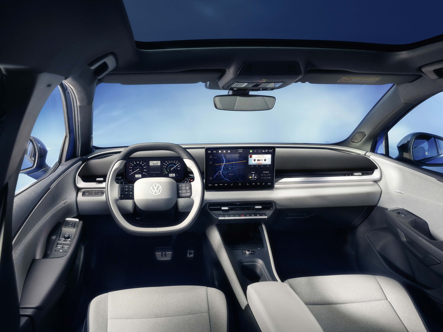 Modern interieur van de blauwe Volkswagen Id.Polo met digitaal dashboard en groot infotainmentscherm.