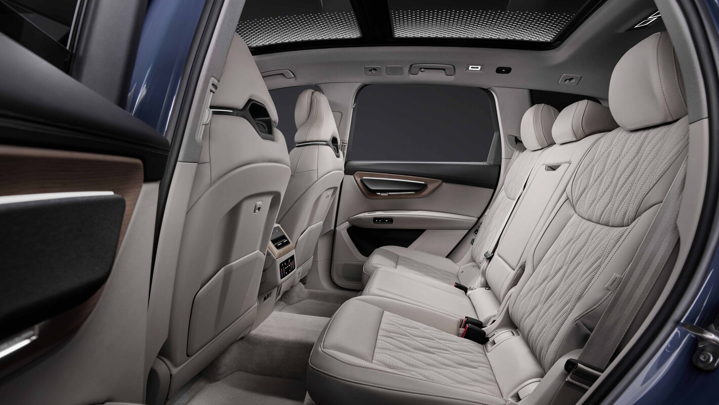 Ruime Audi Q7 achterbank met lichtbeige lederen bekleding en panoramisch dak.