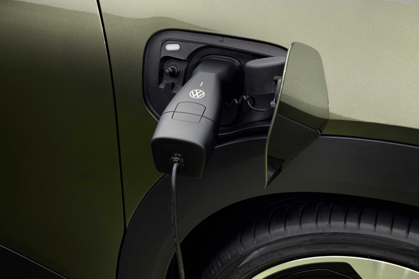 Volkswagen ID. Cross wordt opgeladen, laadstekker in de poort van de elektrische auto.
